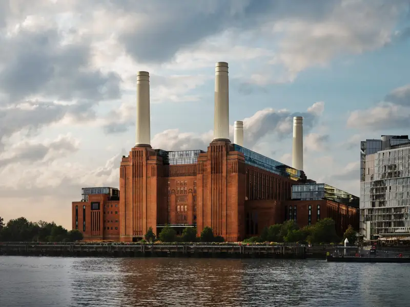 Battersea Power Station seen from across the Thames, its four white chimneys against a cloudy sky
