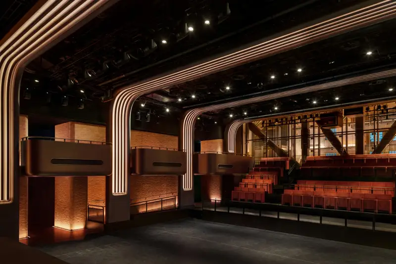 The hall seen from the side, with bronze balconies cantilevered over the floor
